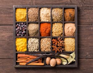 Various herbs and powder spices in box, which are used to make chicken baharat.