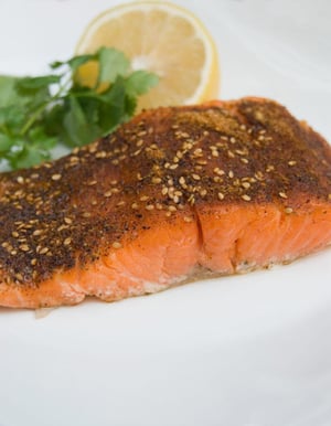A small plate with coriander crusted salmon.