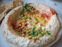 A dish of hummus (A Lebanese Dish) with pine n...