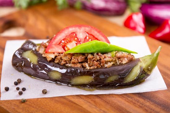 An aubergine is prepared with a spiced meat filling.